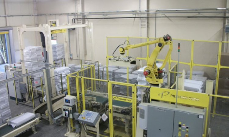 The compact model AR-200 series robotic palletised, which has an option for slip sheet insertion, readies neatly bagged and stacked material for the rotary arm stretch wrapper (left).