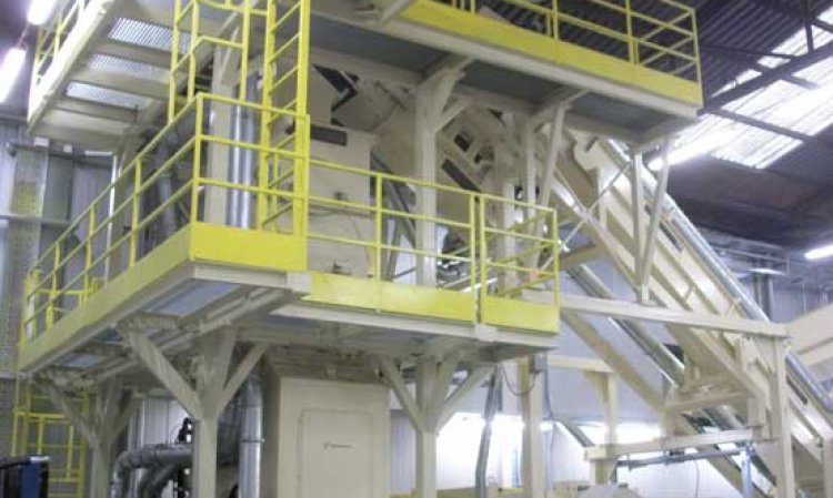 The steeply inclined baler infeed conveyor, (right) transports shredded scrap into the model HVS-140-E radial baler, (upper left) through a specially designed low-profile weighing hopper.
